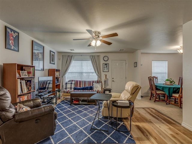 living room with hardwood / wood-style flooring, ceiling fan, and a wealth of natural light