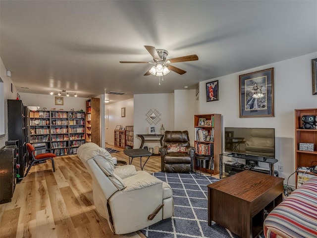 living room featuring hardwood / wood-style floors and ceiling fan