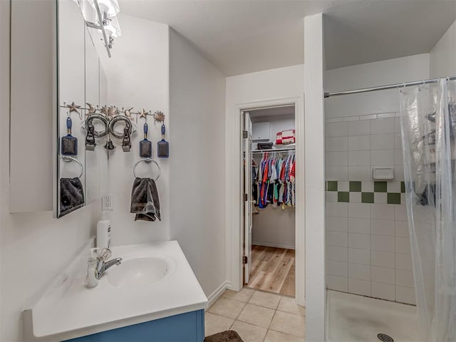 bathroom with walk in shower, tile patterned floors, and vanity