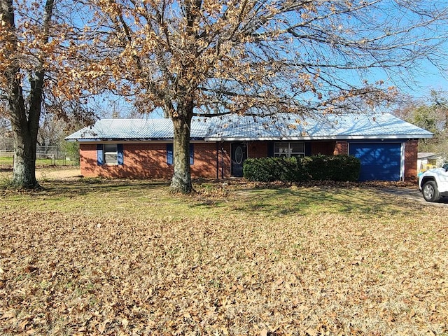 single story home featuring a garage and a front lawn