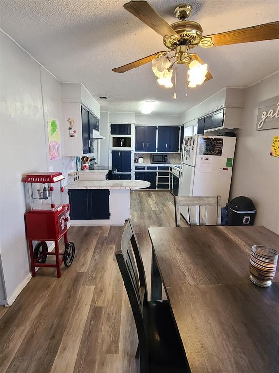 dining room with ceiling fan, dark hardwood / wood-style floors, and a textured ceiling