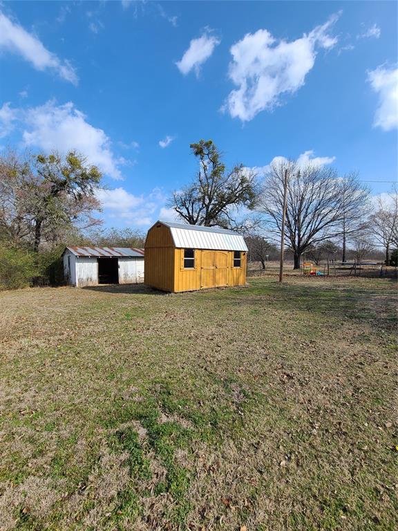 view of yard with a rural view and a storage shed