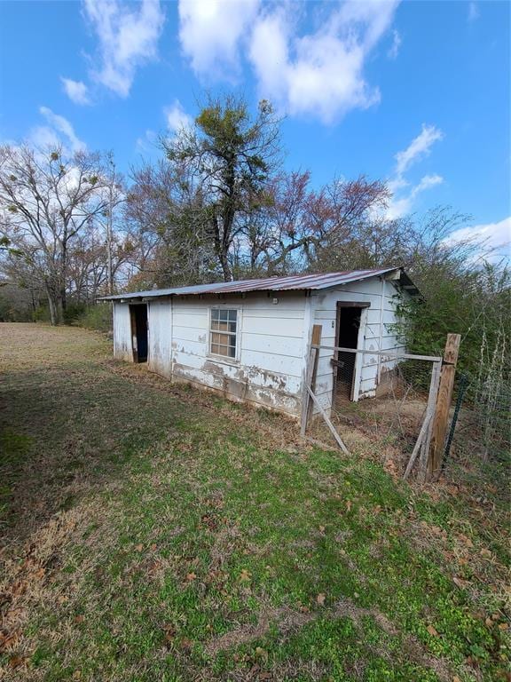 back of house with an outbuilding and a yard