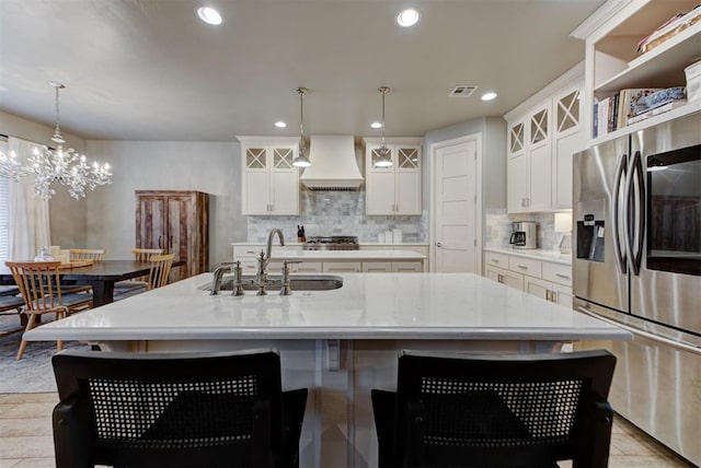 kitchen featuring sink, stainless steel appliances, and an island with sink