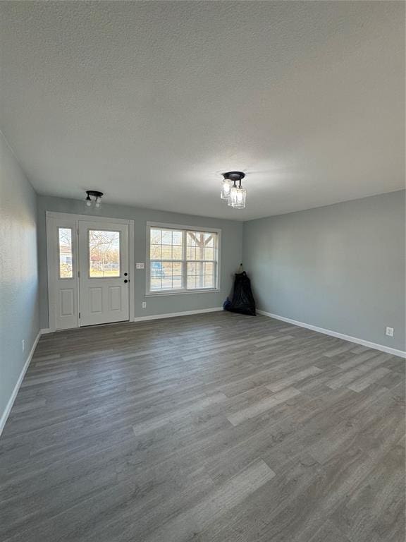 unfurnished room with wood-type flooring and a textured ceiling