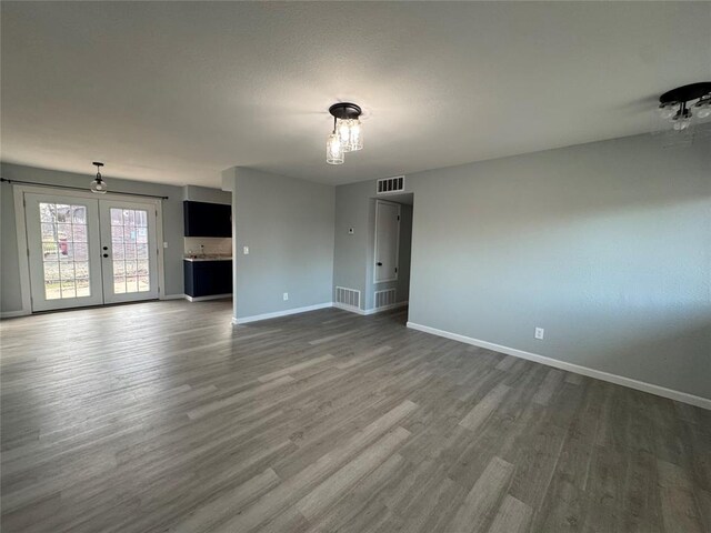 empty room featuring french doors and dark wood-type flooring