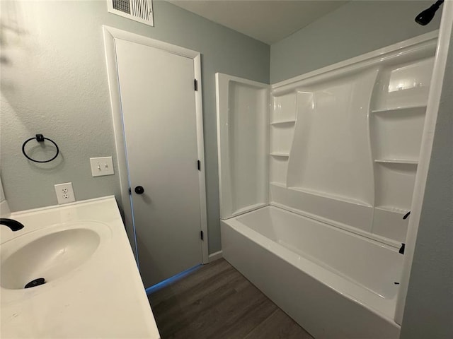 bathroom featuring shower / washtub combination, sink, and hardwood / wood-style floors