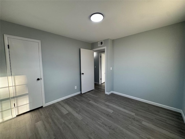 unfurnished bedroom featuring dark hardwood / wood-style flooring