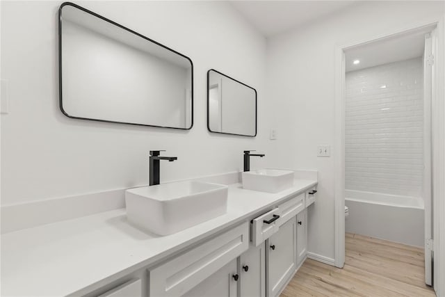 full bathroom with hardwood / wood-style flooring, vanity, toilet, and  shower combination