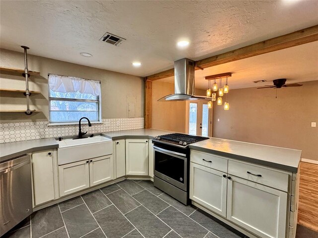 kitchen with sink, island range hood, hanging light fixtures, kitchen peninsula, and stainless steel appliances