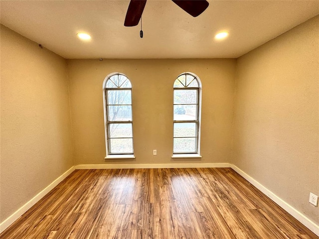 empty room with ceiling fan and wood-type flooring