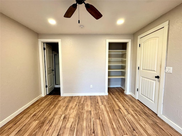 unfurnished bedroom with ceiling fan, ensuite bathroom, light hardwood / wood-style floors, and a closet