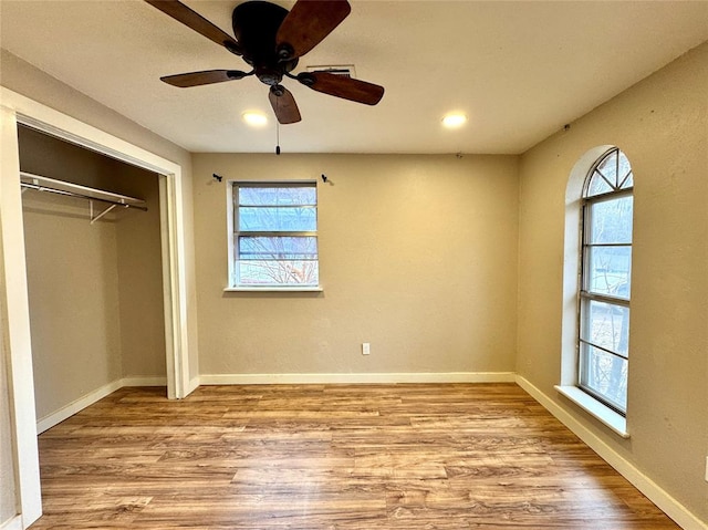 unfurnished bedroom with light hardwood / wood-style flooring, a closet, and ceiling fan