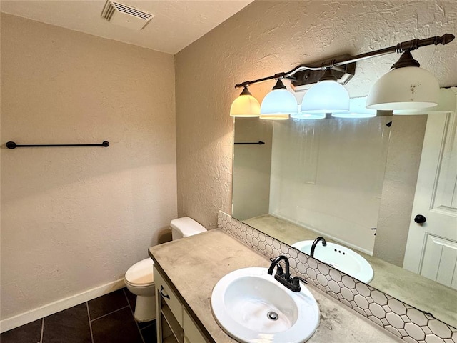 bathroom with vanity, tile patterned floors, and toilet