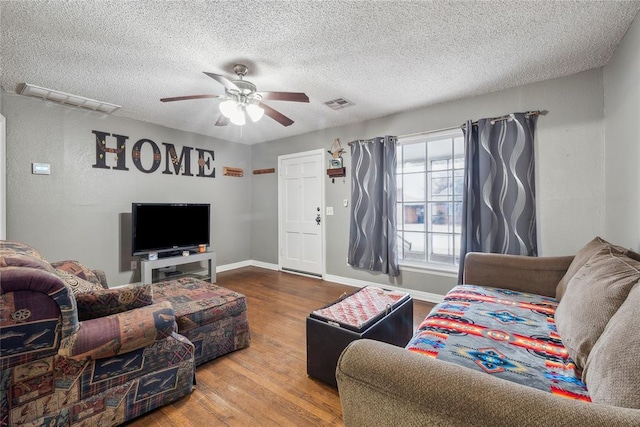 living room with ceiling fan, hardwood / wood-style floors, and a textured ceiling