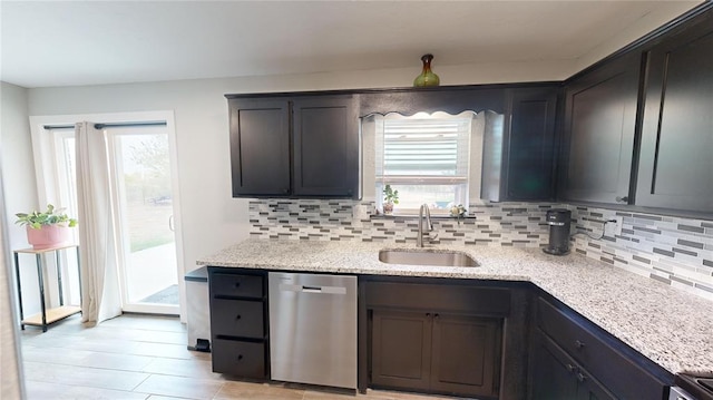 kitchen featuring sink, dishwasher, range, light stone counters, and decorative backsplash