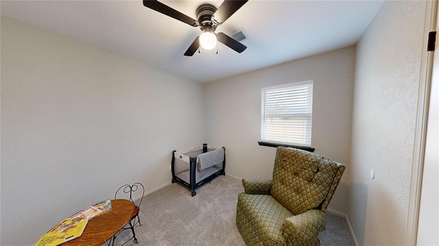 living area with ceiling fan and light colored carpet