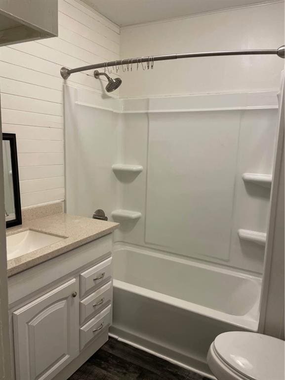 full bathroom featuring toilet, wood walls, shower / bathing tub combination, vanity, and hardwood / wood-style flooring