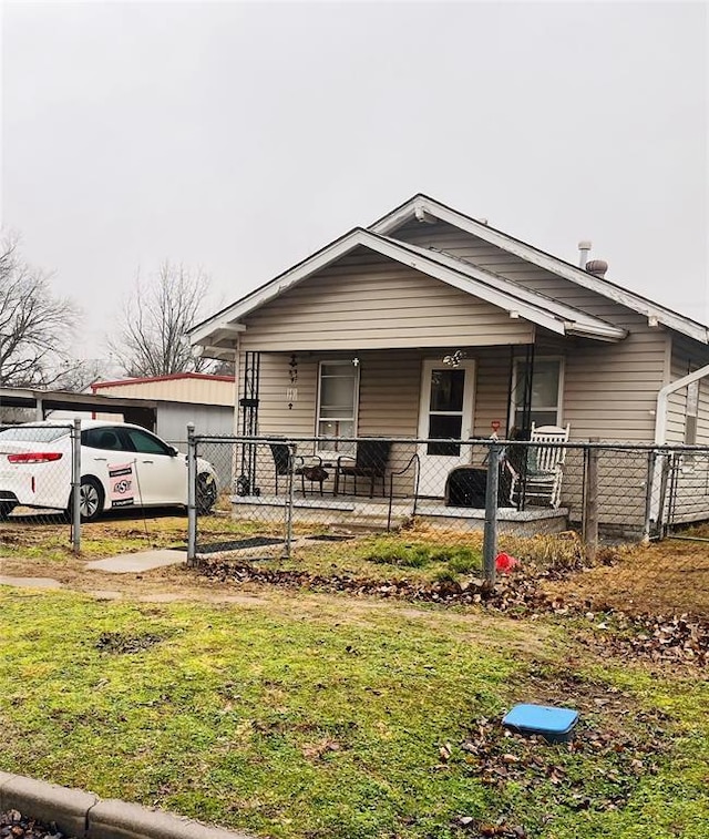 bungalow featuring covered porch and a front lawn