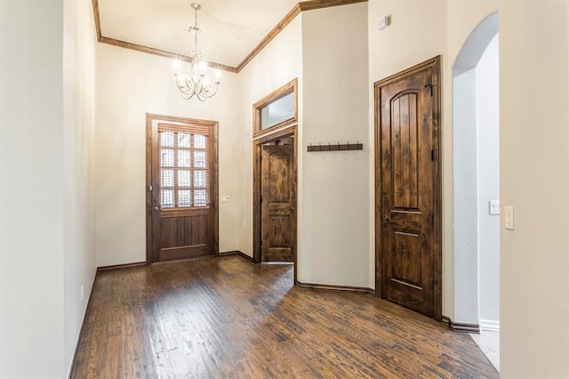 entryway featuring ornamental molding, dark wood-type flooring, and a chandelier