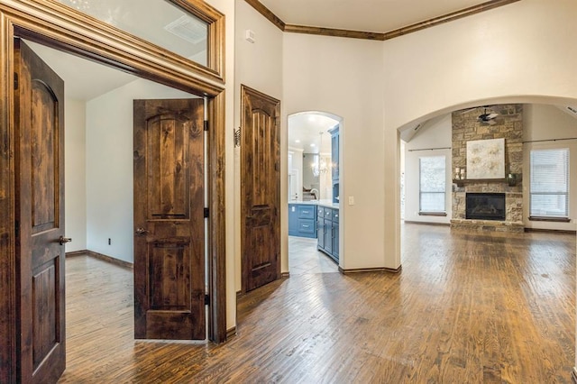 hall with hardwood / wood-style flooring, ornamental molding, and a high ceiling