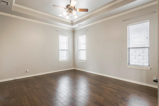 empty room with dark hardwood / wood-style floors, ceiling fan, and a tray ceiling