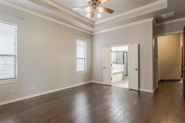 spare room featuring ceiling fan, a tray ceiling, dark hardwood / wood-style flooring, and ornamental molding