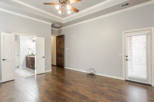 spare room featuring a tray ceiling, ornamental molding, dark hardwood / wood-style floors, and ceiling fan