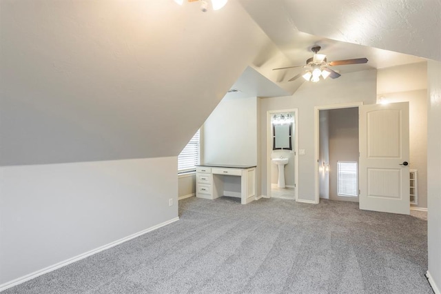 additional living space featuring vaulted ceiling, light colored carpet, and ceiling fan