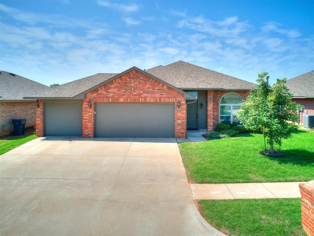 view of front of house featuring central AC, a garage, and a front lawn