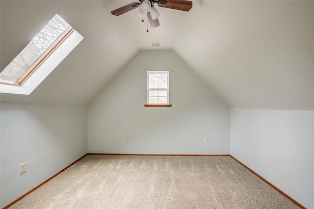 bonus room featuring vaulted ceiling with skylight and carpet