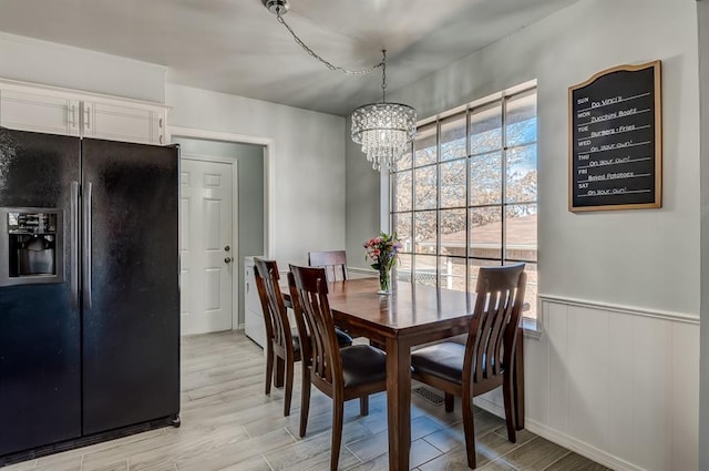 dining area with an inviting chandelier and light hardwood / wood-style floors