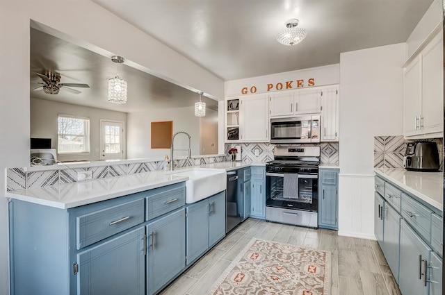 kitchen with sink, white cabinetry, tasteful backsplash, hanging light fixtures, and appliances with stainless steel finishes