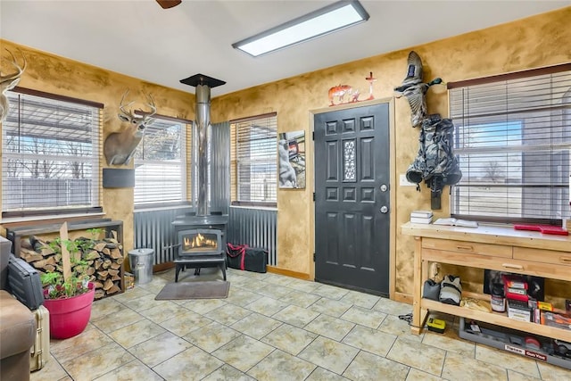 interior space featuring light tile patterned floors and a wood stove