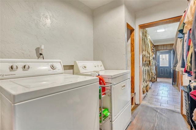 washroom with hardwood / wood-style flooring and washer and clothes dryer