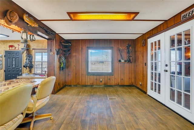 unfurnished office featuring french doors, dark hardwood / wood-style floors, and wood walls