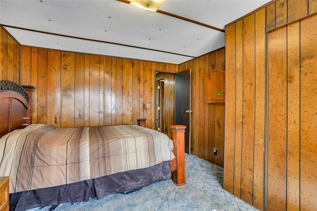 carpeted bedroom with wood walls