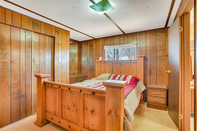 bedroom featuring light colored carpet and wood walls