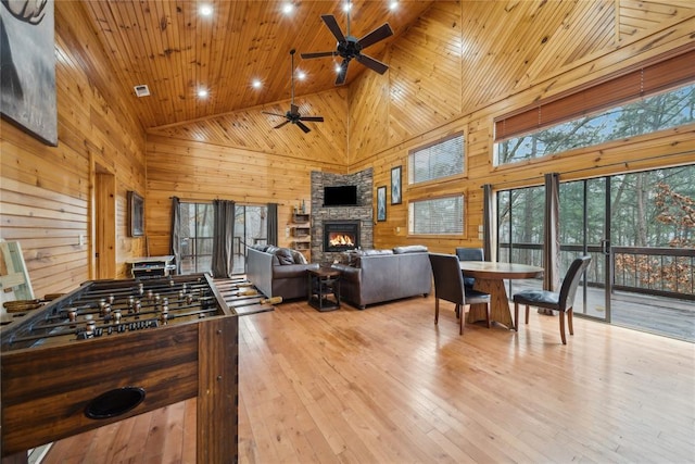 playroom featuring light hardwood / wood-style flooring, wooden ceiling, high vaulted ceiling, and wood walls