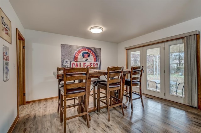 dining room featuring light hardwood / wood-style floors and french doors