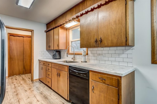 kitchen with tasteful backsplash, sink, dishwasher, and light wood-type flooring