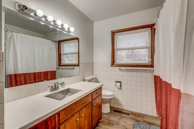 bathroom featuring hardwood / wood-style flooring, vanity, tile walls, and toilet