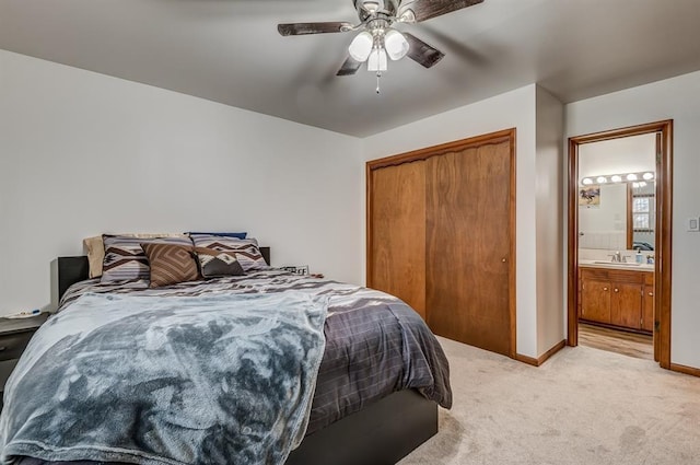 bedroom featuring ceiling fan, light colored carpet, sink, and a closet