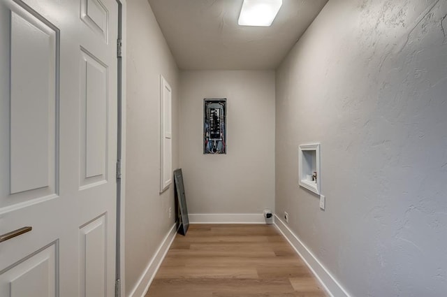 clothes washing area featuring light hardwood / wood-style floors