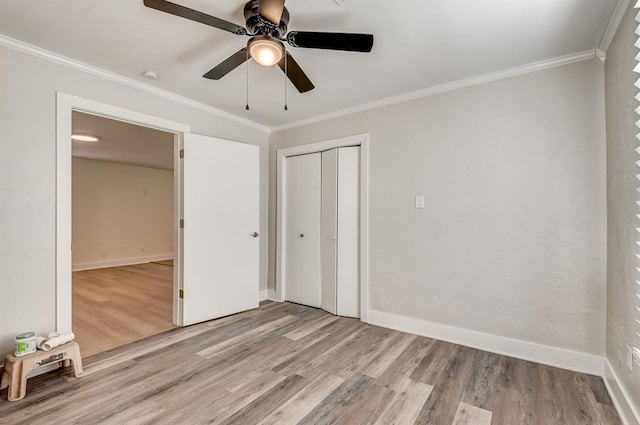 unfurnished bedroom with ceiling fan, a closet, ornamental molding, and light hardwood / wood-style flooring