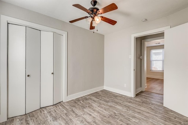 unfurnished bedroom with ceiling fan, light wood-type flooring, and a closet