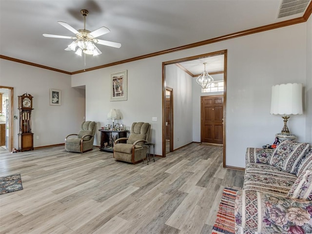 living room featuring baseboards, visible vents, ornamental molding, light wood-style floors, and ceiling fan with notable chandelier