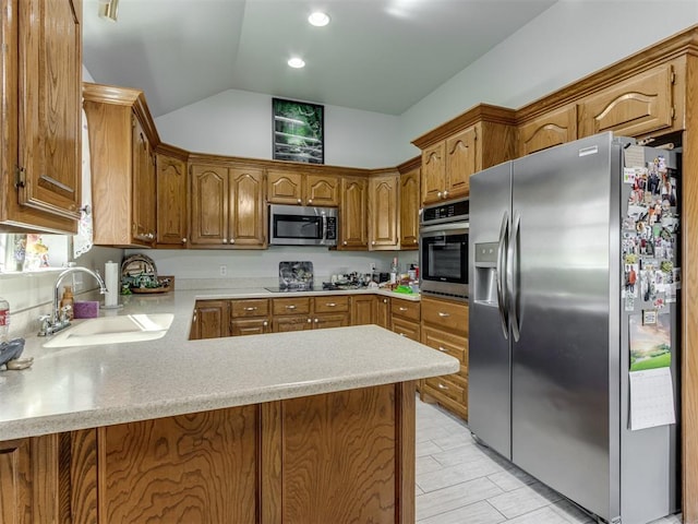 kitchen featuring stainless steel appliances, light countertops, vaulted ceiling, a sink, and a peninsula