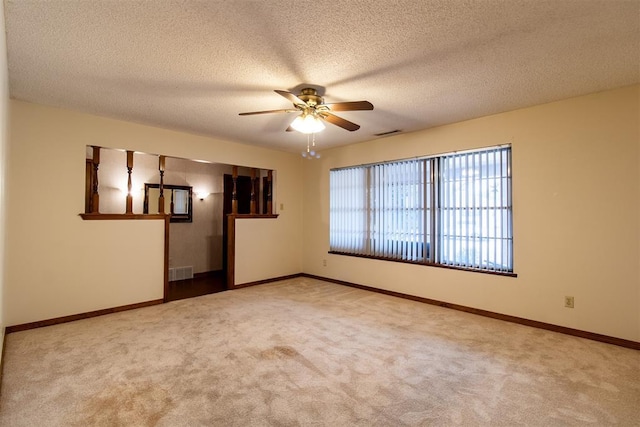 empty room with ceiling fan, carpet floors, and a textured ceiling