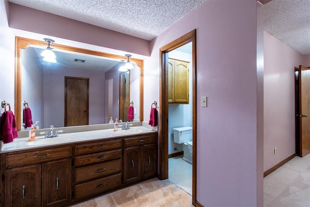 bathroom with vanity, toilet, and a textured ceiling